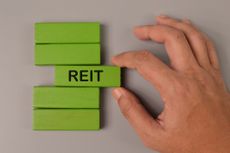 Hand picked wooden block written with Reit stands for Real Estate Investment Trust 