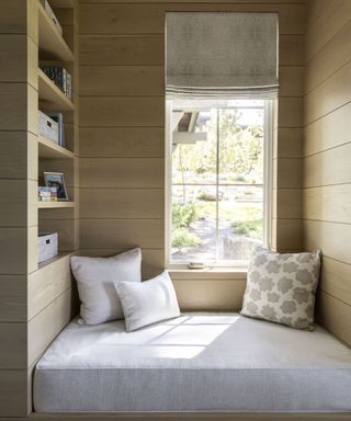 cabin bed in window with pillows and built in shelves