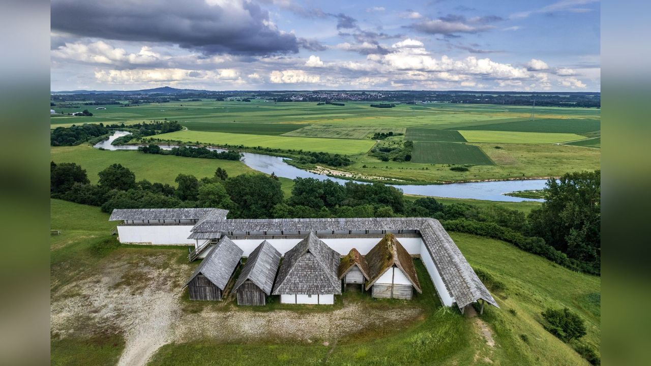 reconstructed buildings and mud brick wall, over the eastern terraces and the Upper Danube River, with the prominent landmark of the Bussen on the left of the horizon.