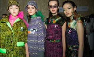 Models wear a range of plaid knit outwear, all with neon detailing
