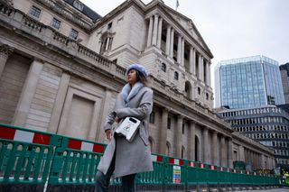 A woman walks in front of the Bank of England