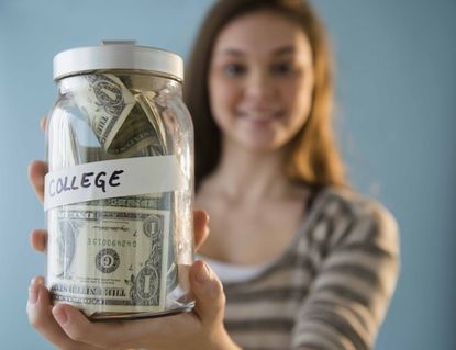 Photo of woman holding a jar of money for college