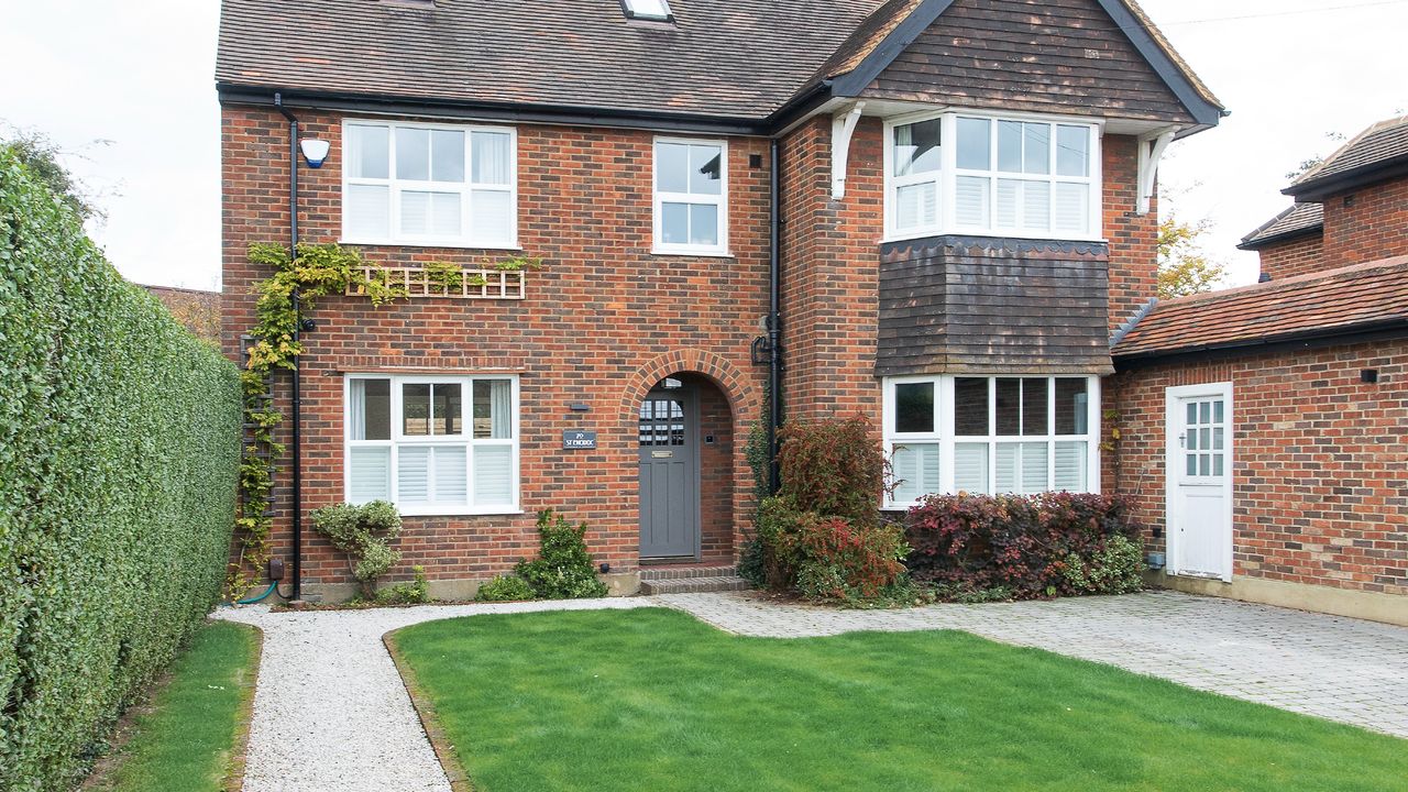 Front garden with grass lawn and gravel path and patio