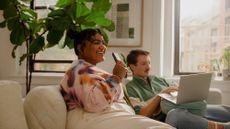 woman and man using tech on sofa