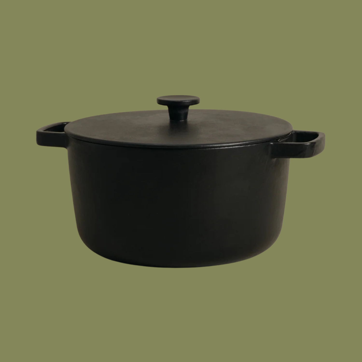 A black cast iron stockpot from Katto, against a navy green background