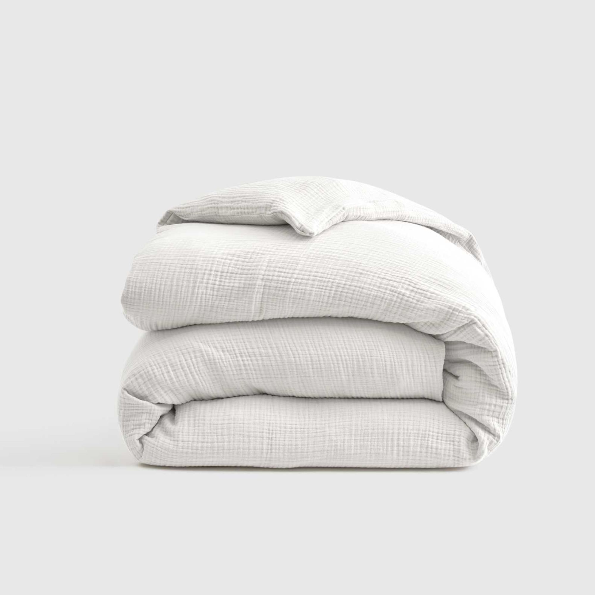 Quince folded white duvet against a white background