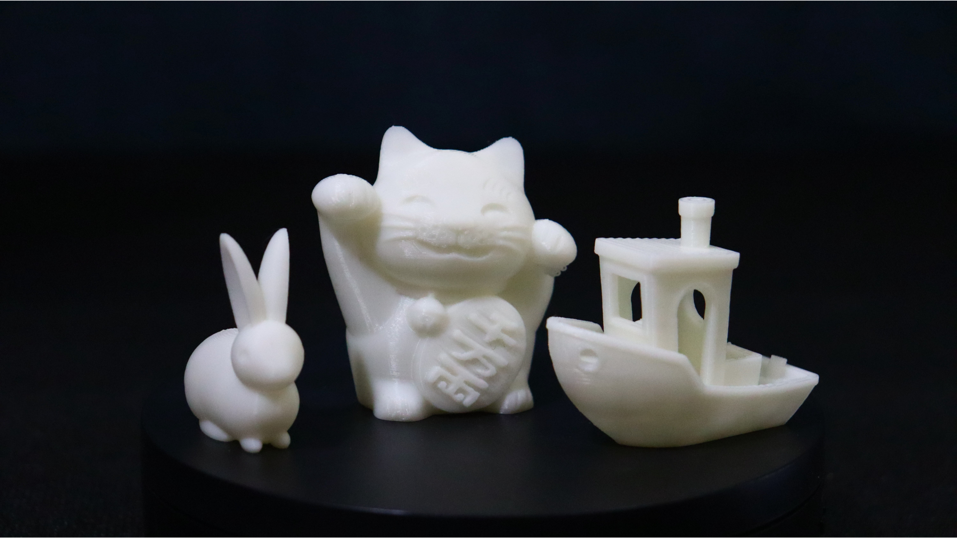 Three test prints from the Creality Ender 5 S1 - a rabbit, a lucky cat, and a benchy boat.
