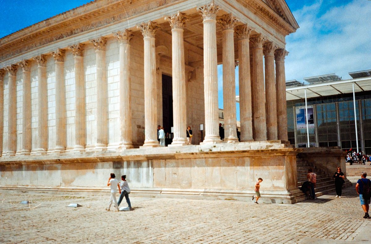Scanned and digitized film image, using Valoi Easy 35 Pro V2 and Negative Lab Pro Lightroom plugin. Image shows people walking in front of an ancient-looking building