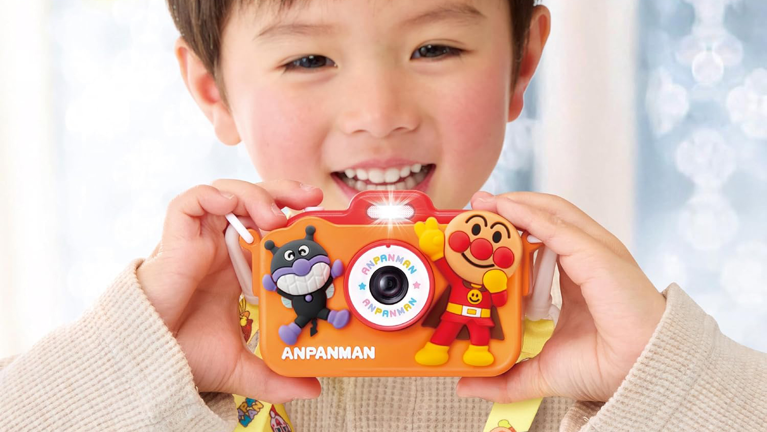 A smiling child holding the Agatsuma Anpanman Kids Camera