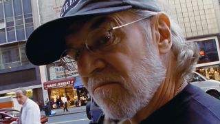 George Carlin, wearing baseball cap, walking down the streets of New York City, featured in HBO doc George Carlin's American Dream.