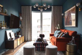 blue living room with orange sofa in an apartment