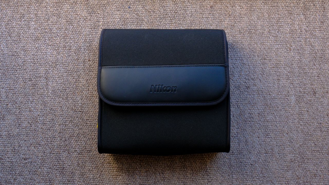The closed protective case for the Nikon Action 7x50 binoculars on a brown carpet.