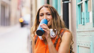 Woman drinking from a reusable water bottle outside