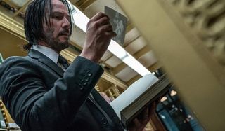 John Wick: Chapter 3 - Parabellum John looks at a photo in the library