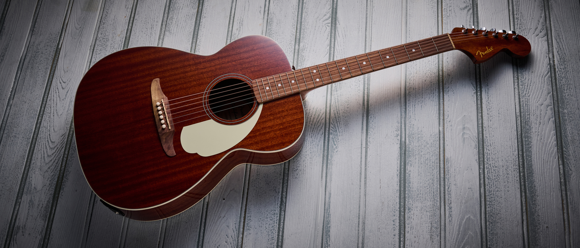 A Fender California Standard Monterey E acoustic guitar lying on some white wood panelling