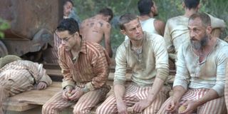 Rami Malek Charlie Hunnam Papillon Sitting On A Bench