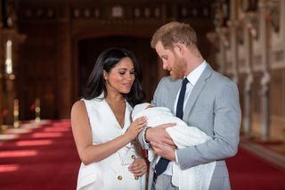 Prince Harry, Duke of Sussex and Meghan, Duchess of Sussex, pose with their newborn son during a photocall in St George's Hall at Windsor Castle on May 8, 2019 in Windsor, England. The Duchess of Sussex gave birth at 05:26 on Monday 06 May, 2019. (Photo by Dominic Lipinski - WPA Pool/Getty Images)