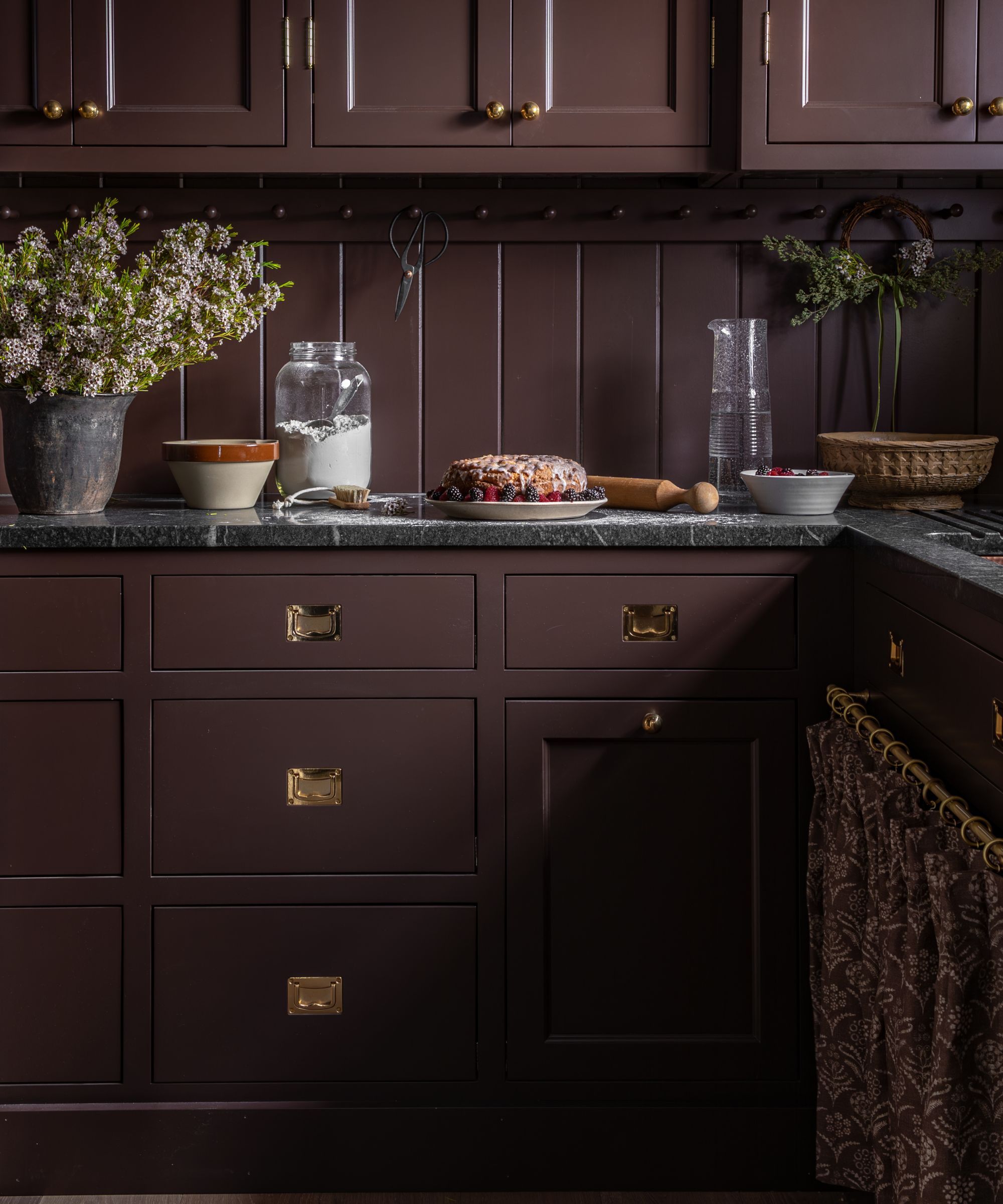 chocolate brown color drenched small kitchen pantry with tongue and groove panelling and dark marble countertops