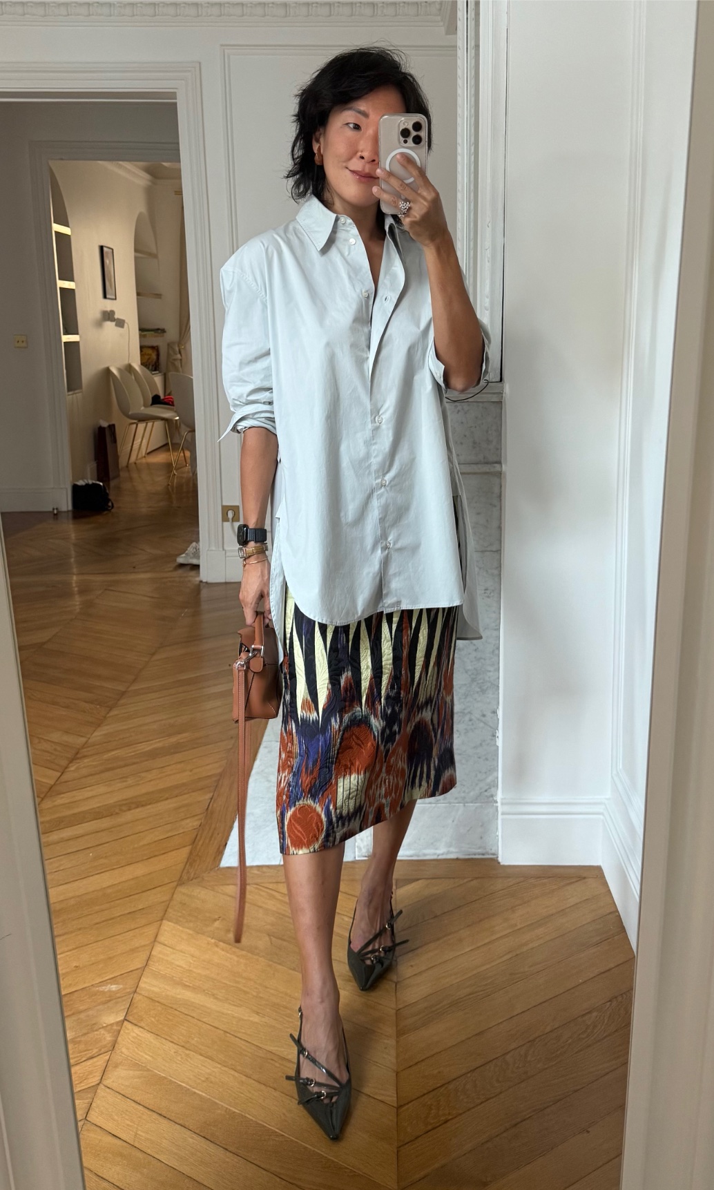 Irene Kim wearing a button-down shirt, a skirt, and heels