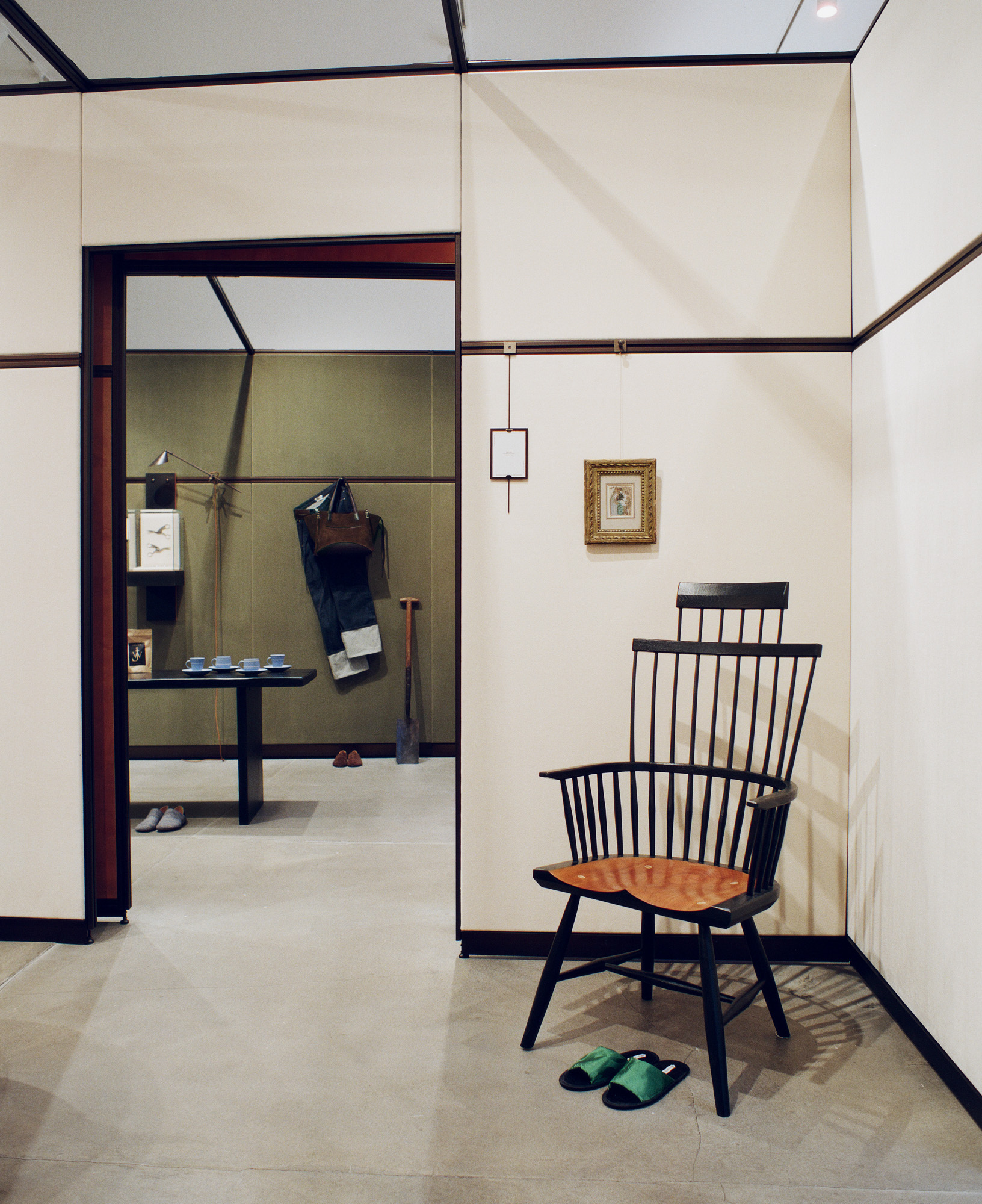 Interior with wooden chair and green slippers, previewing Jonathan Anderson's brand direction