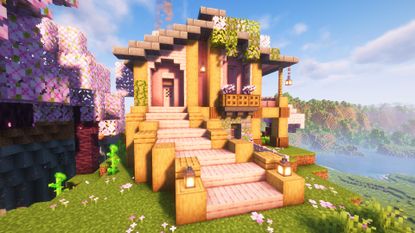 A pink, wood, and stone cottage build in cherry grove biome in Minecraft.