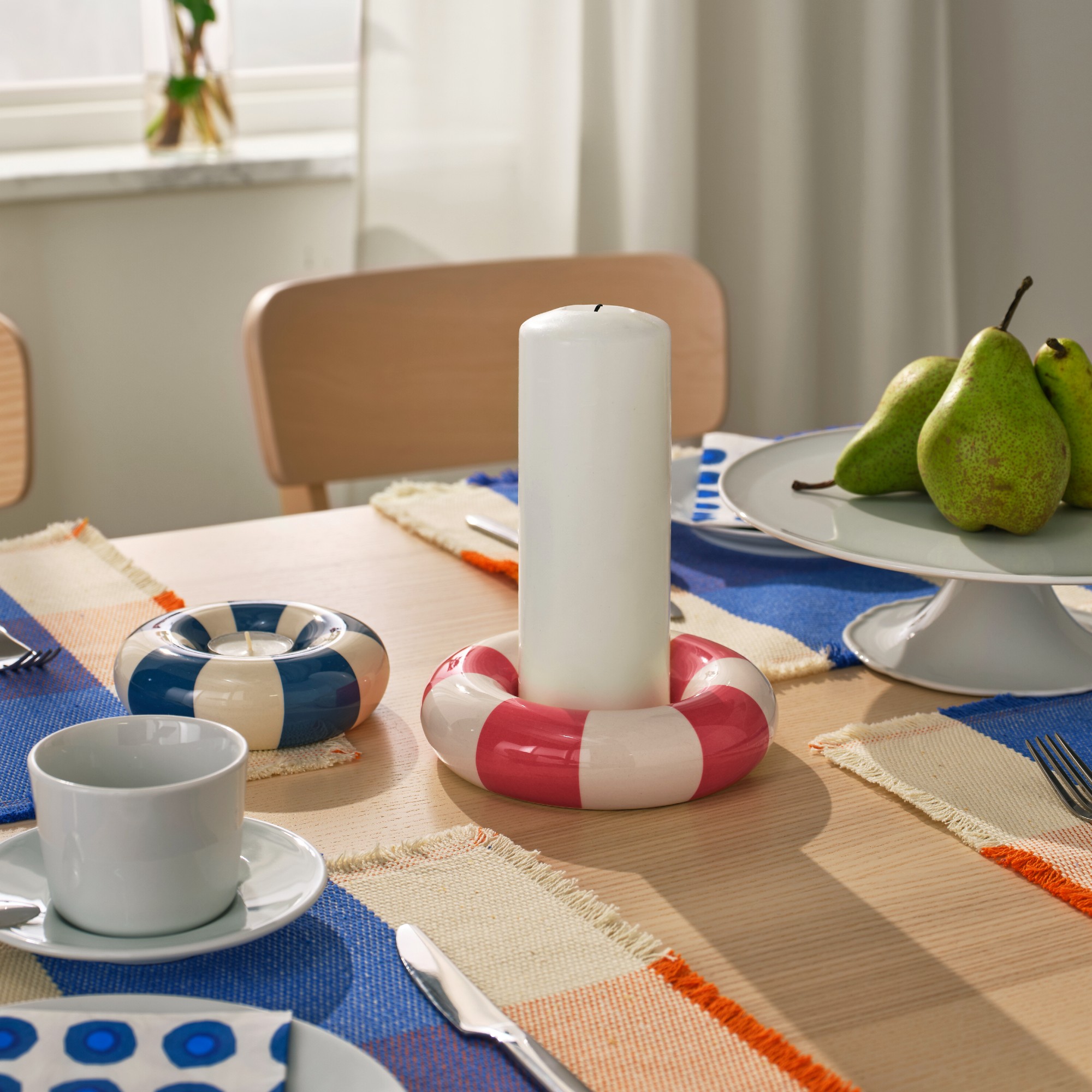 A set dining table with two IKEA TRÄDSTAM candle holders in the middle