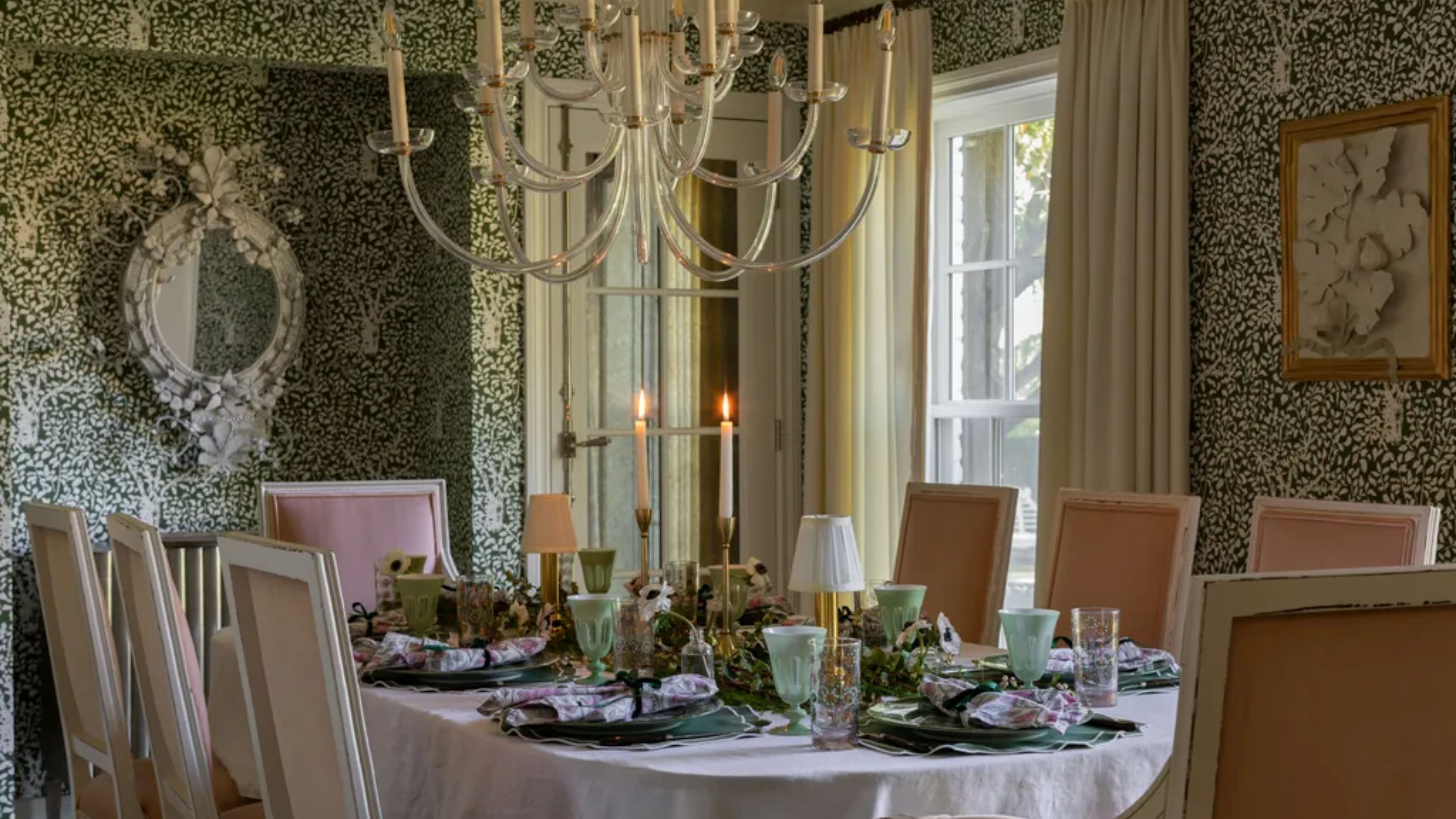 Eclectic Thanksgiving table setting inside of dining room decorated with green floral patterned wallpaper and an ornate accent mirror