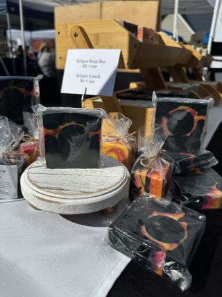 An image of black soap bars with total solar eclipse patterns in pinkish orange.