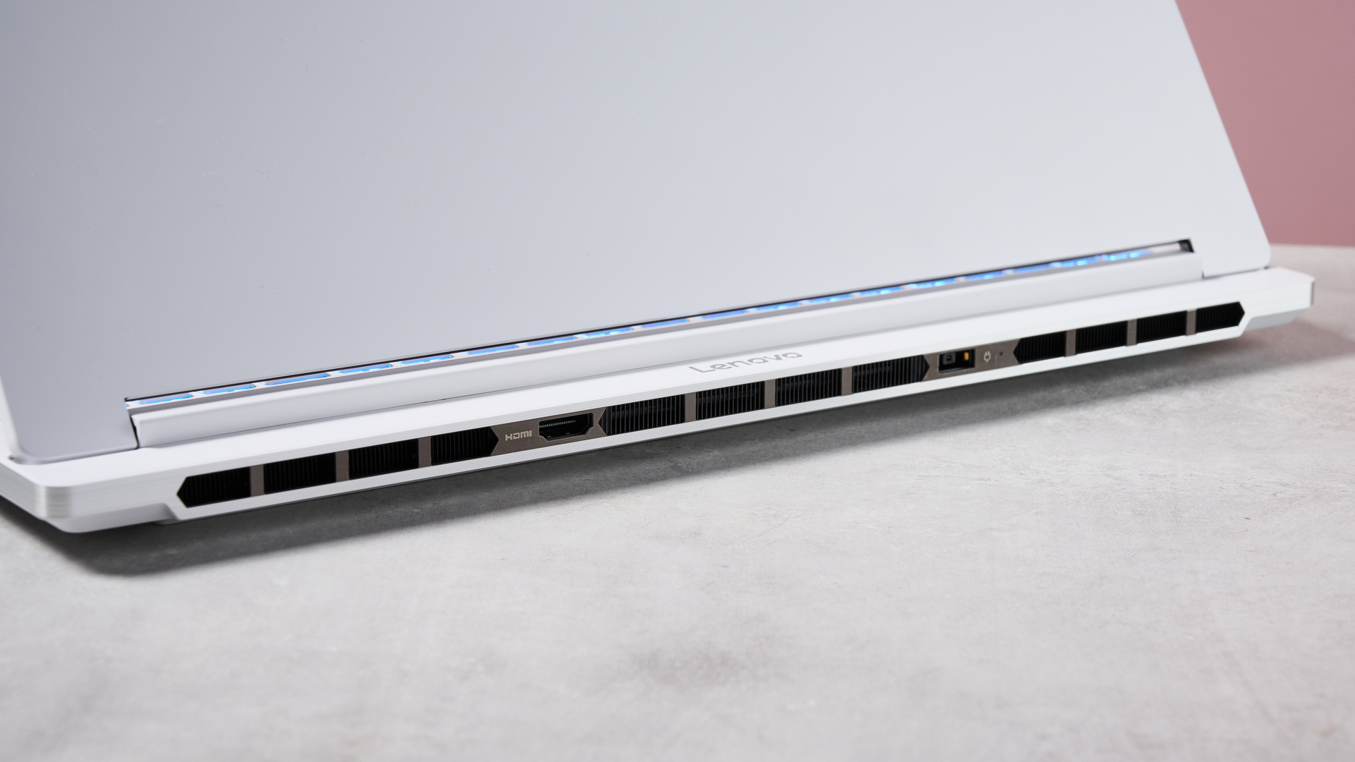 Close-up of rear ventilation on Lenovo Legion 7i Gen 10, on desk with pink wall in background