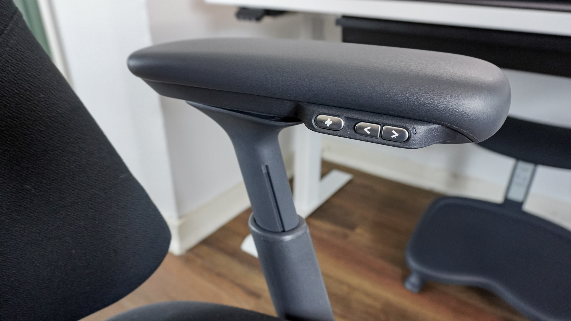 A closeup shot of the buttons on the LiberNovo Omni's left armrest that you use to control its adjustable lumbar depth