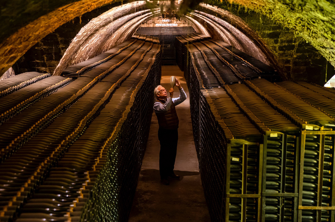 A man stands in the centre of an old wine cellar