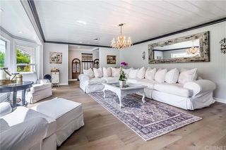 A living room with greige walls, white sofas, and black accents