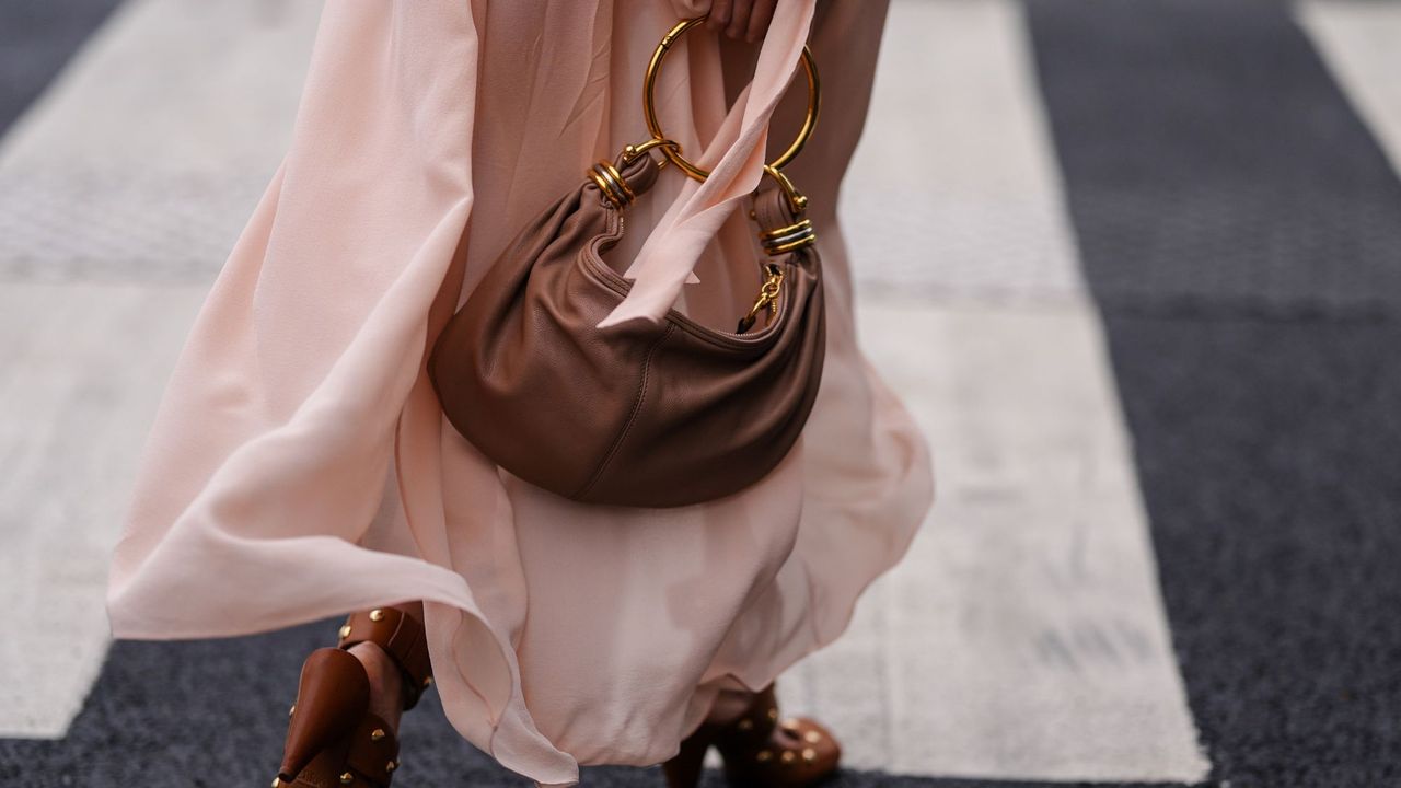 A guest at Paris fashion week crossing the road wearing a floaty Chloé dress, reminiscent of a lightweight perfume