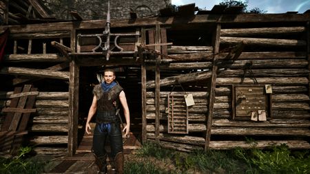 Gothic Remake Scatty's chest: A player stood outside Scatty's hut near the castle walls in the Old Camp, during the day, facing the camera.