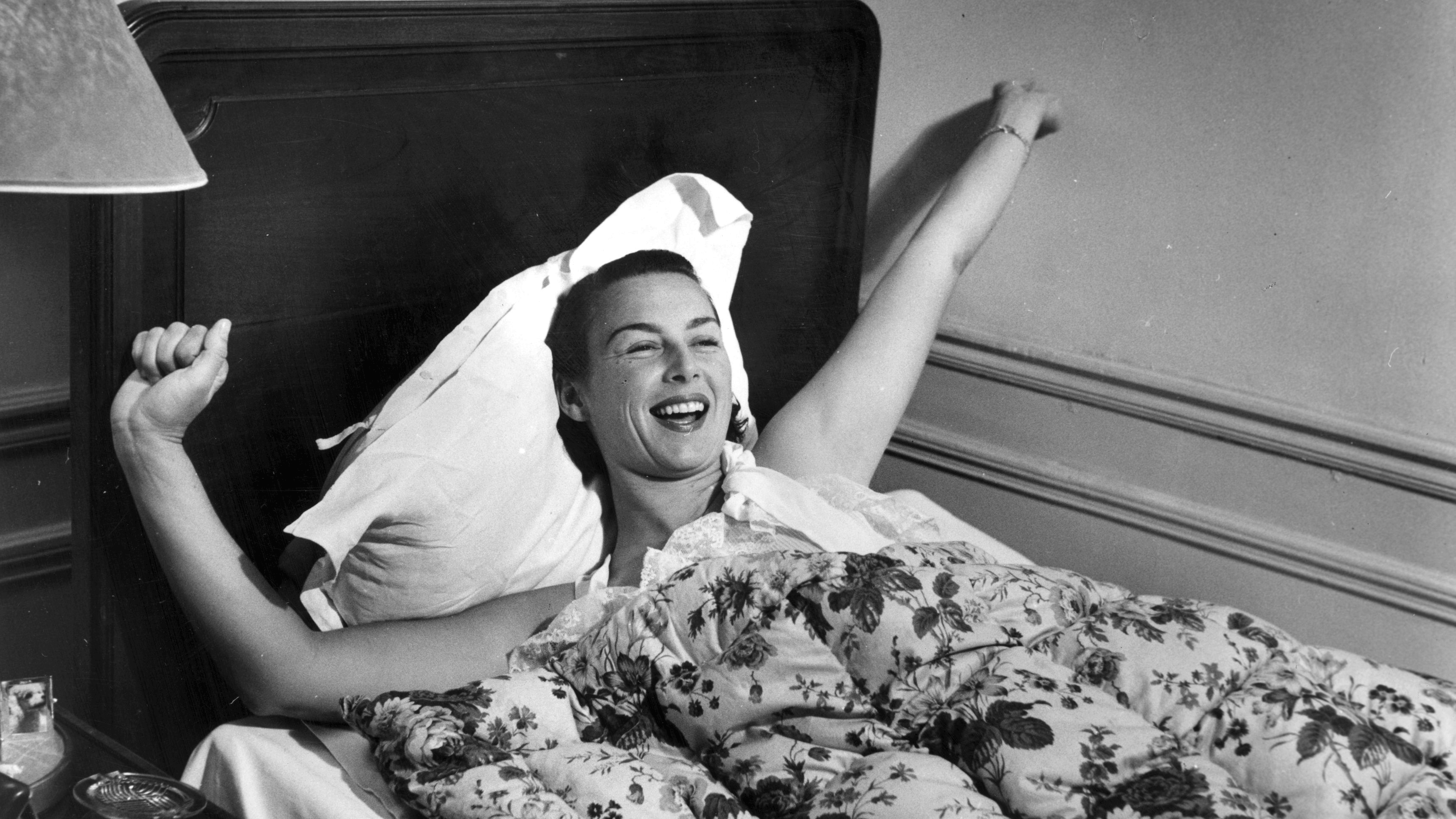 Vintage image of woman waking up in bed