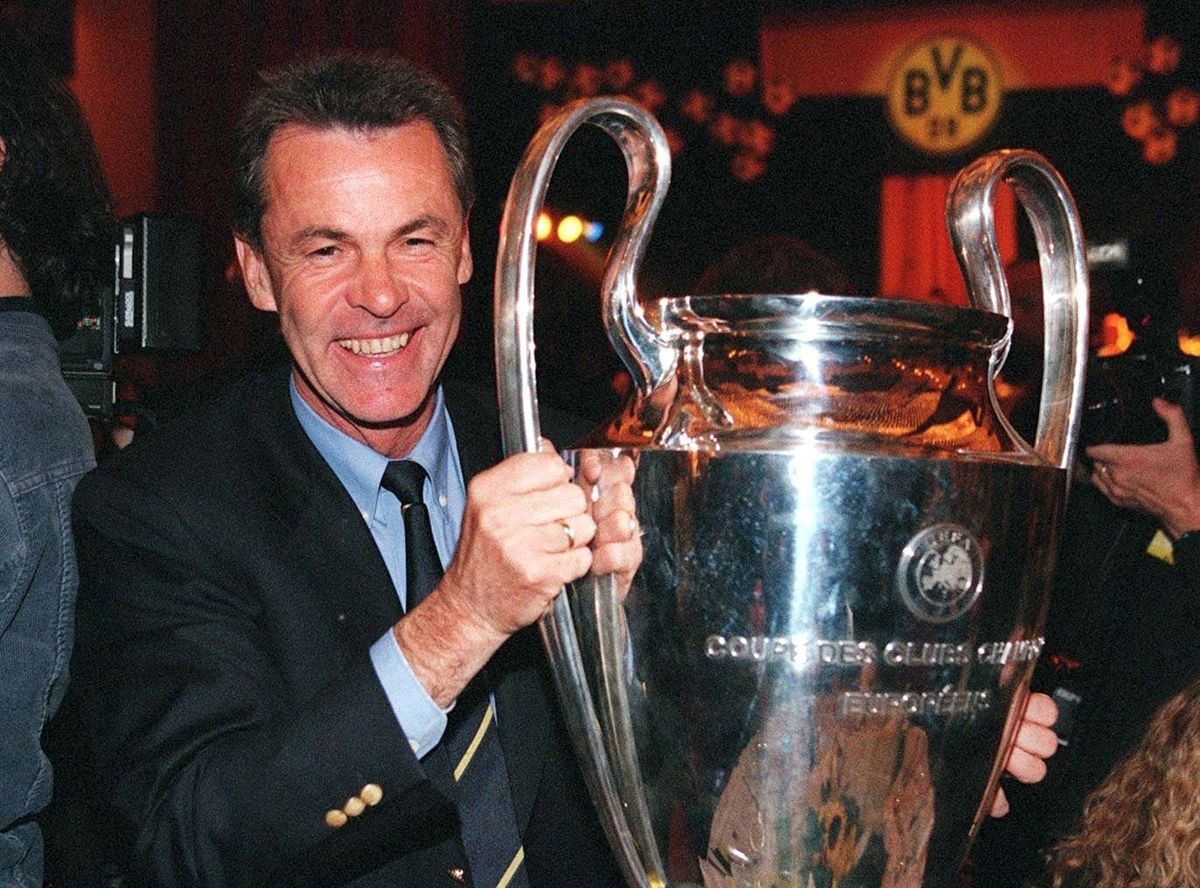 Borussia Dortmund manager Ottmar Hitzfeld smiles while holding the Champions League trophy, 1997