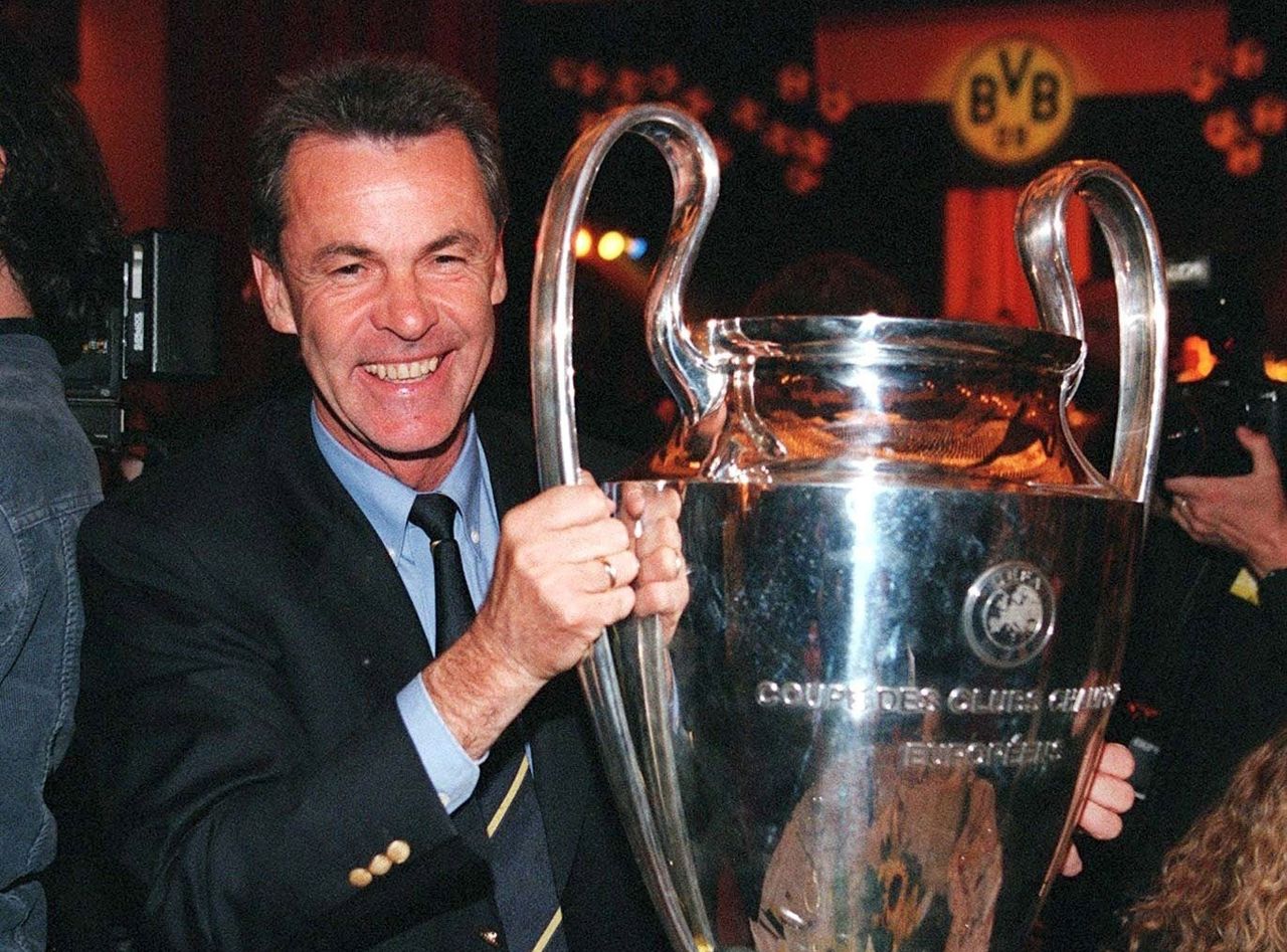 Borussia Dortmund manager Ottmar Hitzfeld smiles while holding the Champions League trophy, 1997
