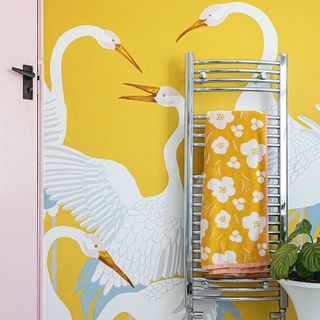 bathroom with yellow painted mural of crane birds