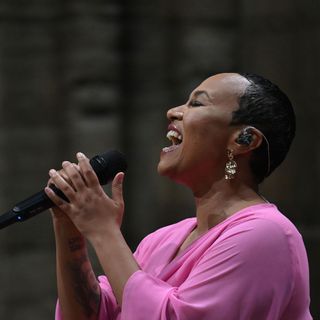 Emeli Sandé in a pink dress, singing