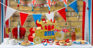 coronation party table with coronation decorations including carriage cake stand