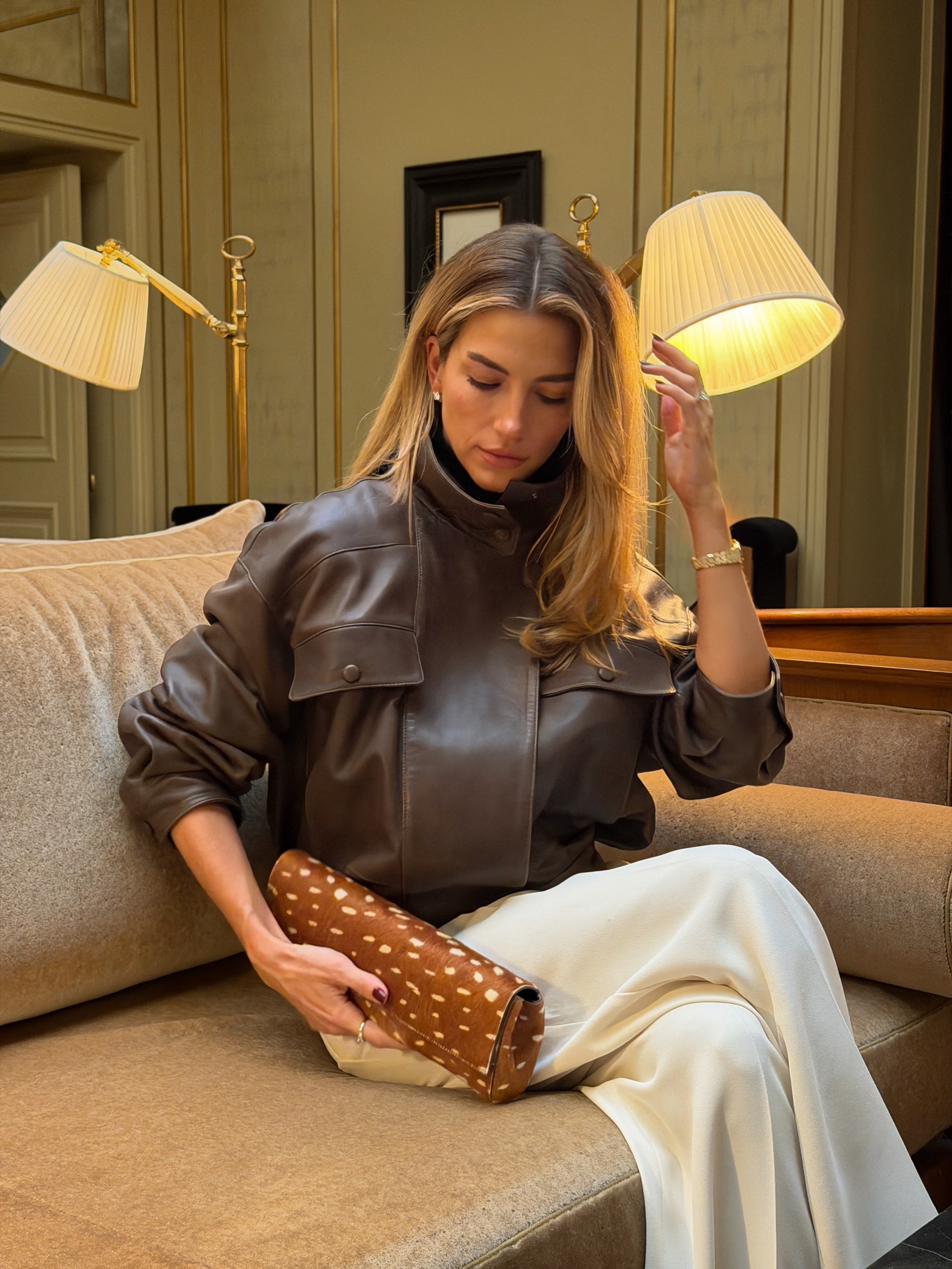 Woman holding a fawn-print clutch bag.