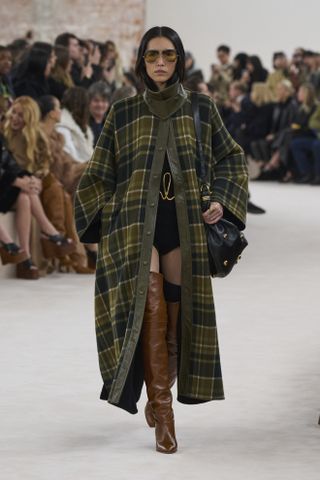 woman in check cape walking the Chloé runway