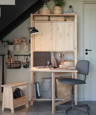 A wooden fold out desk with storage unit built in