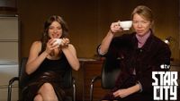 Two female actors holding coffee cups