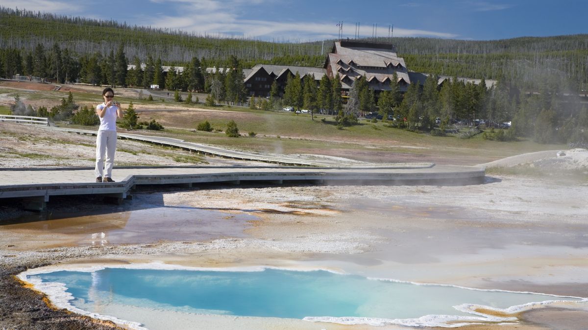 Woman standing on boardwalk by Upper Geyser Basin, Yellowstone National Park