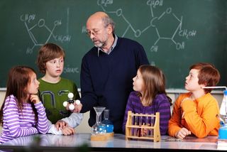 Male science teacher with elementary school kids.