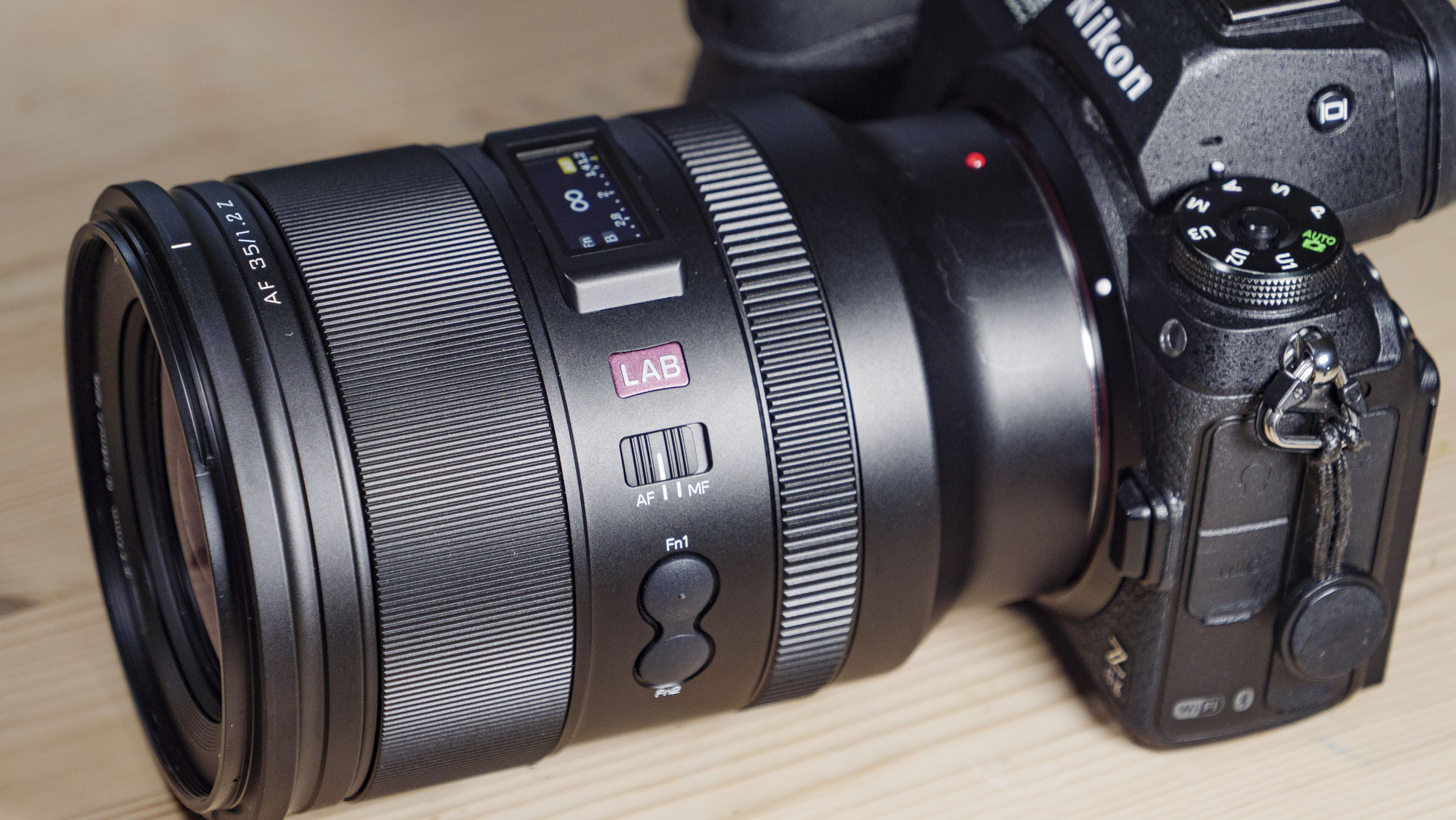 Viltrox AF 35mm F1.2 LAB Z lens for Nikon, attached to a Nikon Z6 II, on a wooden table, close. up of the controls