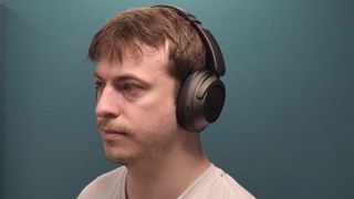 TechRadar's review team member Harry Padoan wearing the 1More Sonoflow Pro HQ51, on blue background