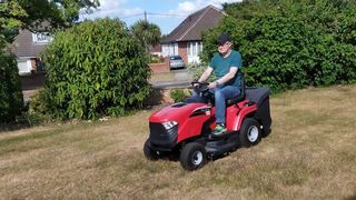 A man using the Mountfield 1330M riding lawn mower to cut the grass