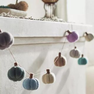 A string of felt pumpkins on a mantel